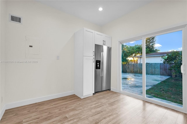 unfurnished room featuring light wood-type flooring and electric panel