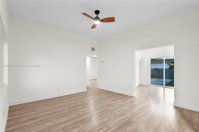 spare room with light wood finished floors, baseboards, visible vents, and a ceiling fan