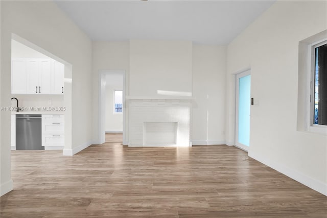 unfurnished living room with light hardwood / wood-style flooring and a wealth of natural light