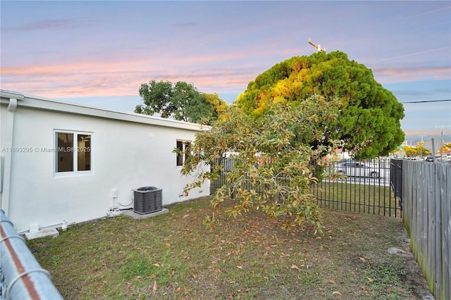 view of yard featuring fence and central AC