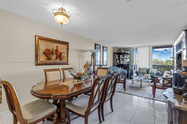 dining space featuring plenty of natural light, light tile patterned floors, and a textured ceiling