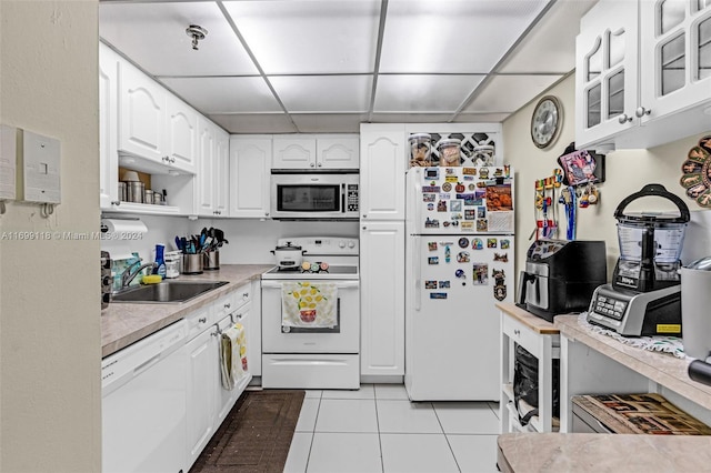 kitchen with sink, white cabinets, a drop ceiling, and white appliances