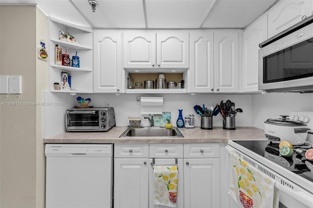 kitchen featuring white cabinets, white appliances, and sink