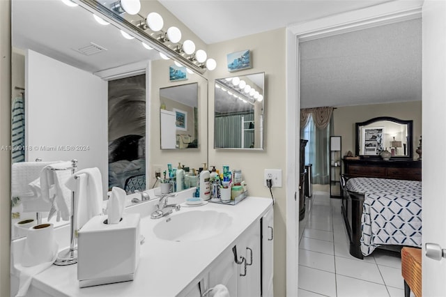 bathroom with tile patterned flooring, vanity, and a textured ceiling