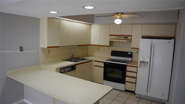 kitchen featuring white appliances, sink, light tile patterned floors, a textured ceiling, and kitchen peninsula