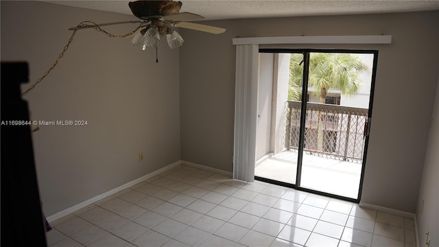 tiled spare room with a textured ceiling and ceiling fan