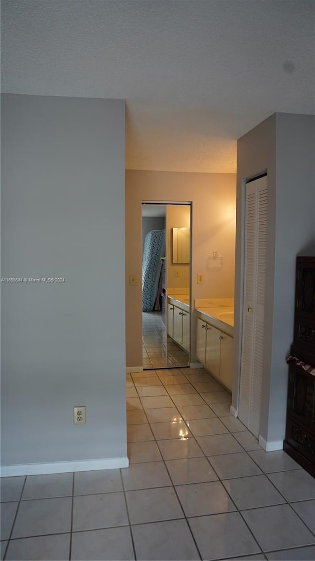 hall with light tile patterned floors and a textured ceiling