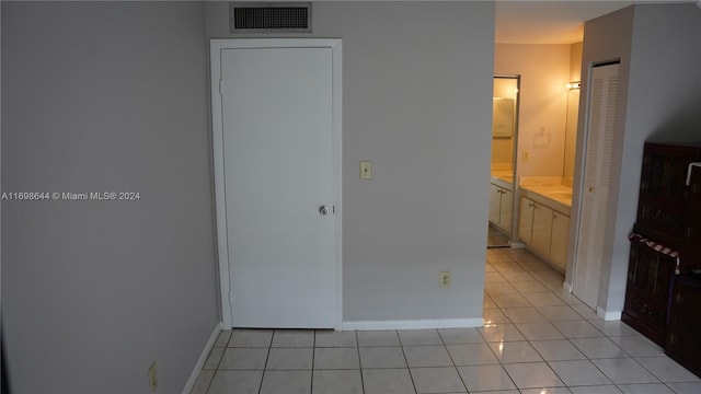 interior space featuring light tile patterned floors and connected bathroom