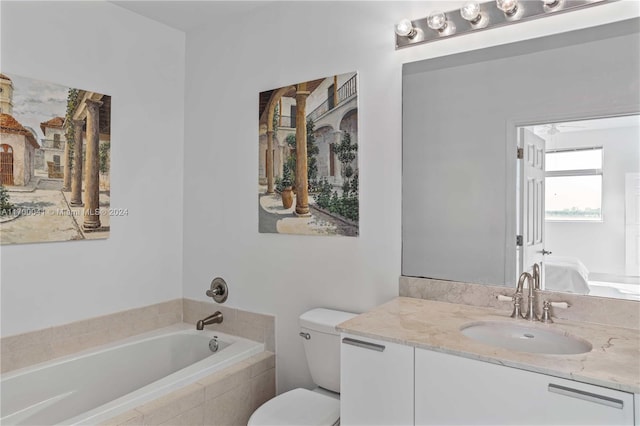 bathroom featuring vanity, ceiling fan, toilet, and tiled tub