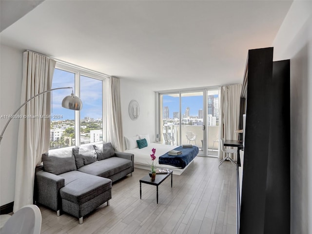 living room with light hardwood / wood-style floors and a wall of windows