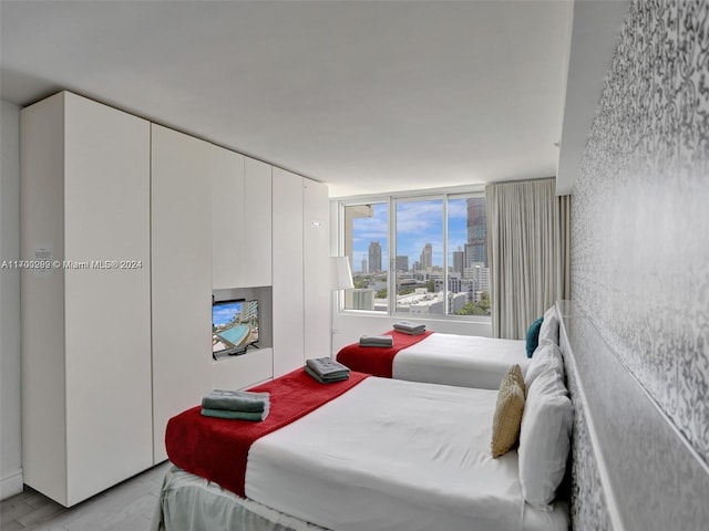 bedroom featuring expansive windows and light wood-type flooring