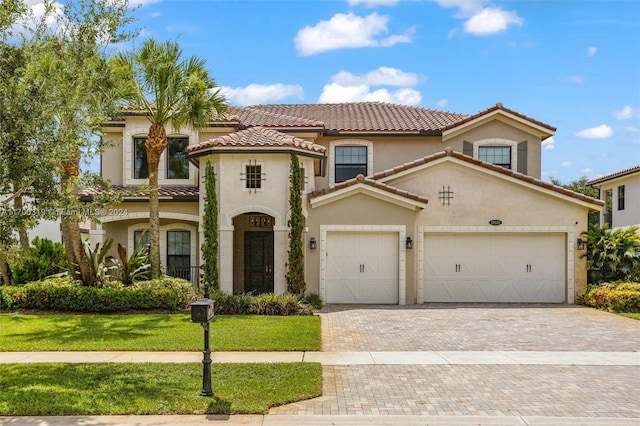 mediterranean / spanish-style home featuring a front yard and a garage