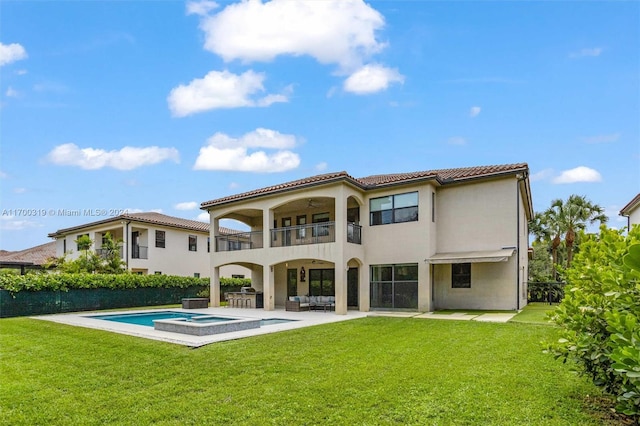 rear view of house featuring a lawn, a pool with hot tub, an outdoor hangout area, a balcony, and a patio area