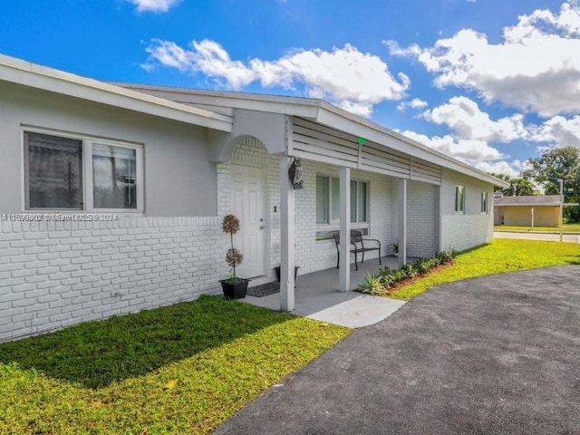 property entrance with a porch and a yard