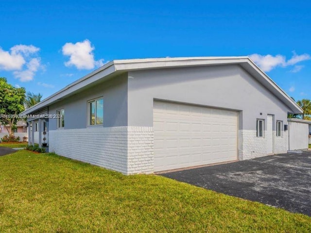 view of side of home featuring a yard and a garage