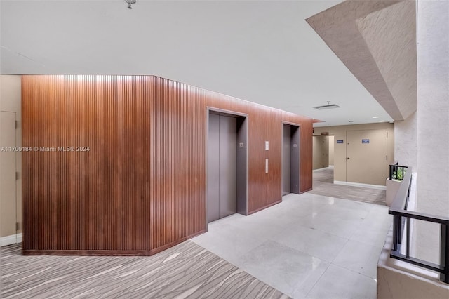 hall featuring elevator and wood walls