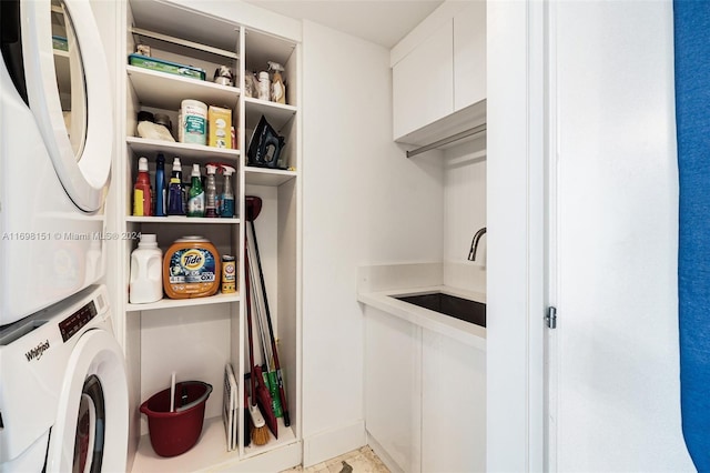 clothes washing area featuring stacked washer and dryer and sink