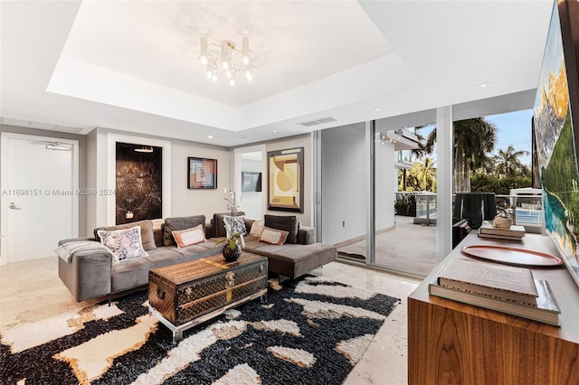 living room featuring a chandelier and a tray ceiling