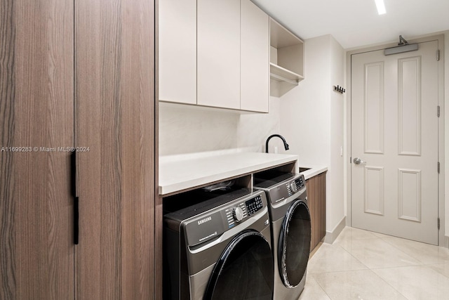 clothes washing area with washer and dryer, cabinets, light tile patterned floors, and sink