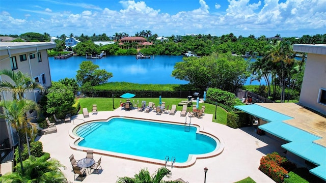 view of pool featuring a patio area, a lawn, and a water view