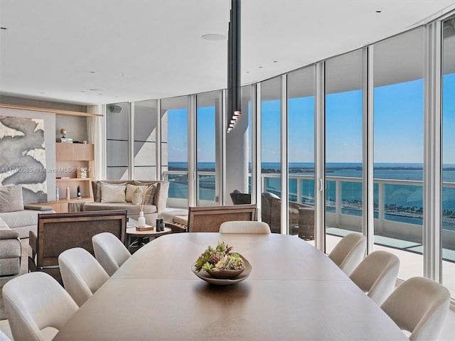 dining space with built in features, a wall of windows, and a water view