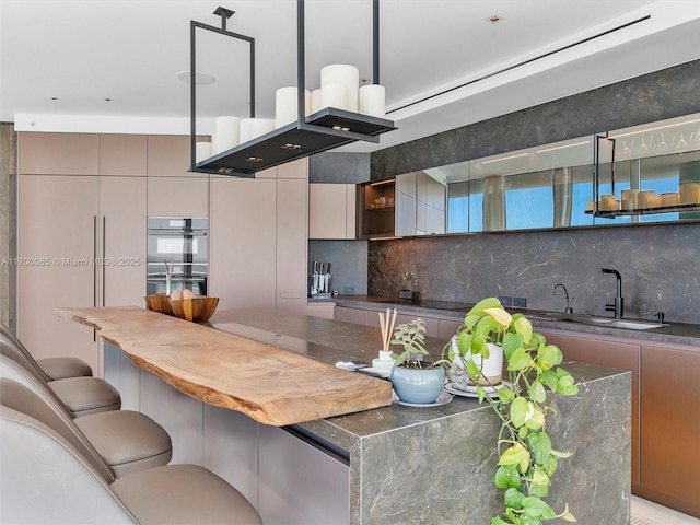 kitchen with open shelves, tasteful backsplash, double wall oven, and a sink