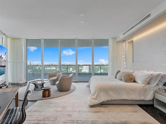 bedroom featuring expansive windows and hardwood / wood-style floors