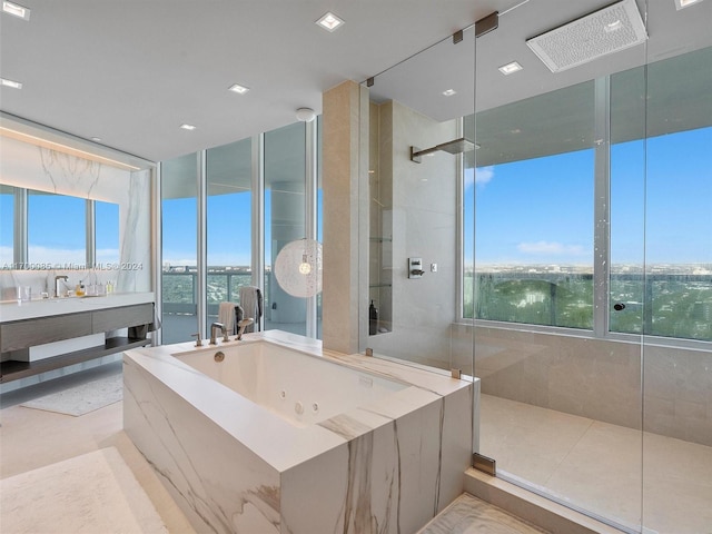 bathroom featuring a wealth of natural light, tile patterned floors, vanity, and shower with separate bathtub