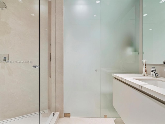 bathroom with a tile shower and vanity