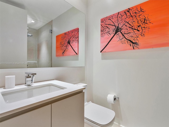 bathroom with toilet, vanity, and walk in shower