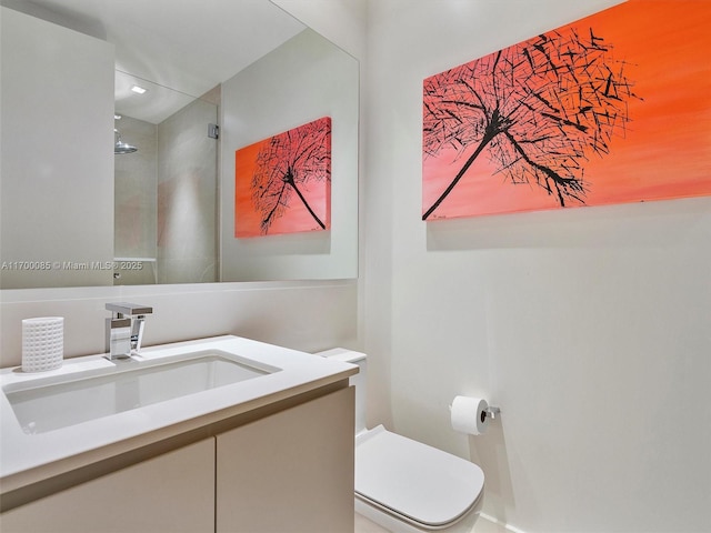 bathroom with recessed lighting, toilet, vanity, and tiled shower