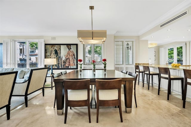 dining space featuring crown molding and a notable chandelier