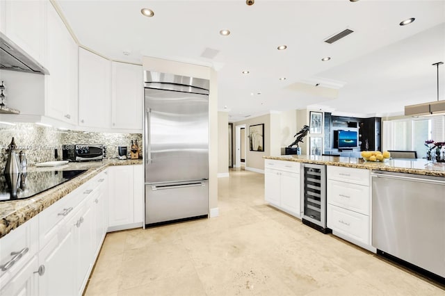 kitchen featuring exhaust hood, wine cooler, light stone countertops, white cabinetry, and stainless steel appliances