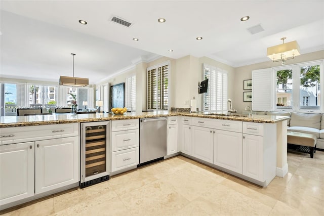 kitchen with stainless steel dishwasher, a wealth of natural light, and beverage cooler