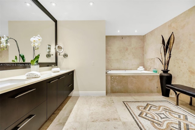 bathroom with tiled tub, tile patterned flooring, and vanity