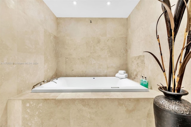 bathroom featuring tile walls and tiled tub