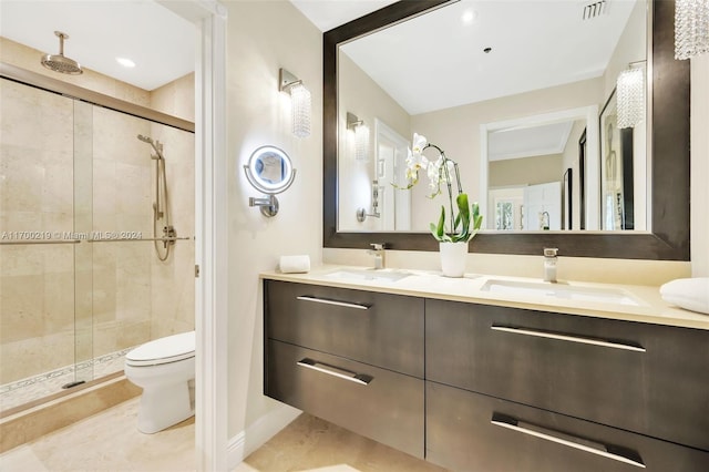 bathroom with tile patterned floors, vanity, toilet, and a shower with door