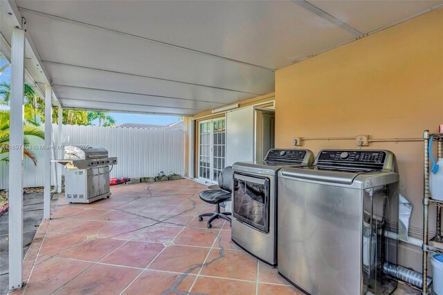 clothes washing area featuring washing machine and clothes dryer and light tile patterned flooring