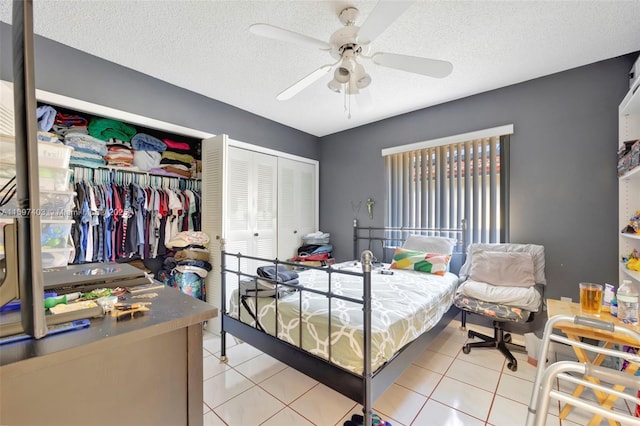 699 NW 134th Pl, Miami, FL 33182 - bedroom with light tile patterned floors, a textured ceiling, a ceiling fan, and multiple closets