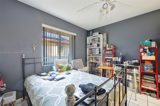 tiled bedroom featuring ceiling fan and a textured ceiling