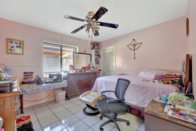 bedroom with ceiling fan, light tile patterned floors, and a closet