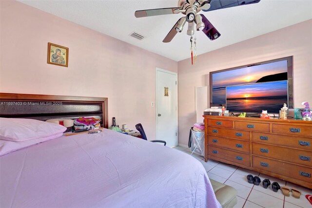 tiled bedroom featuring ceiling fan