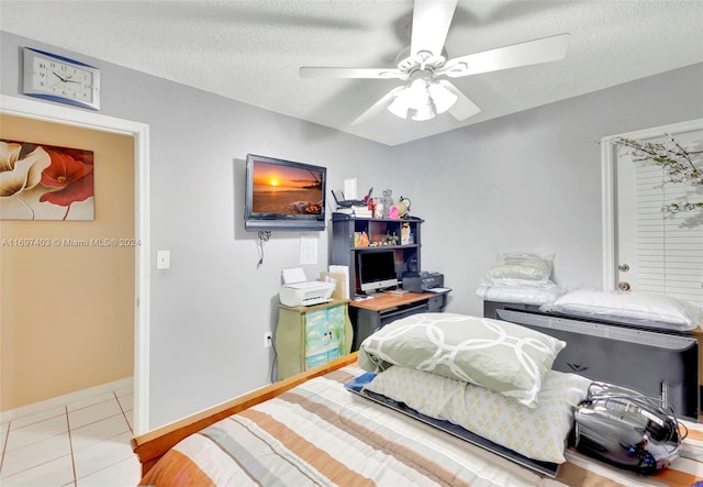 tiled bedroom featuring ceiling fan and a textured ceiling