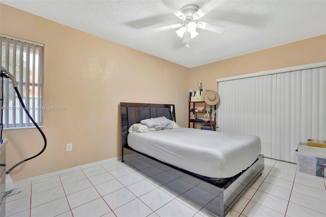 699 NW 134th Pl, Miami, FL 33182 - tiled bedroom featuring a textured ceiling, ceiling fan, and baseboards
