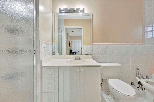 bathroom featuring tile patterned flooring, a bidet, an enclosed shower, vanity, and tile walls