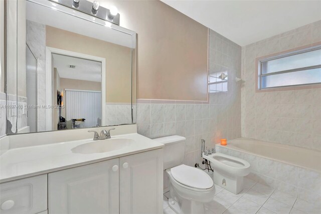 bathroom featuring tile patterned floors, a bidet, toilet, vanity, and tile walls