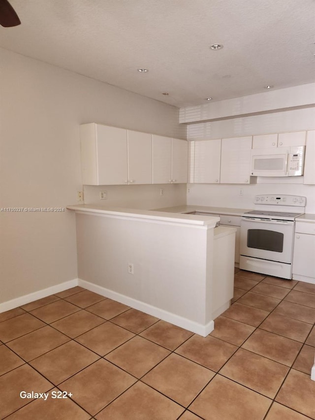 kitchen with kitchen peninsula, white cabinets, light tile patterned flooring, and white appliances