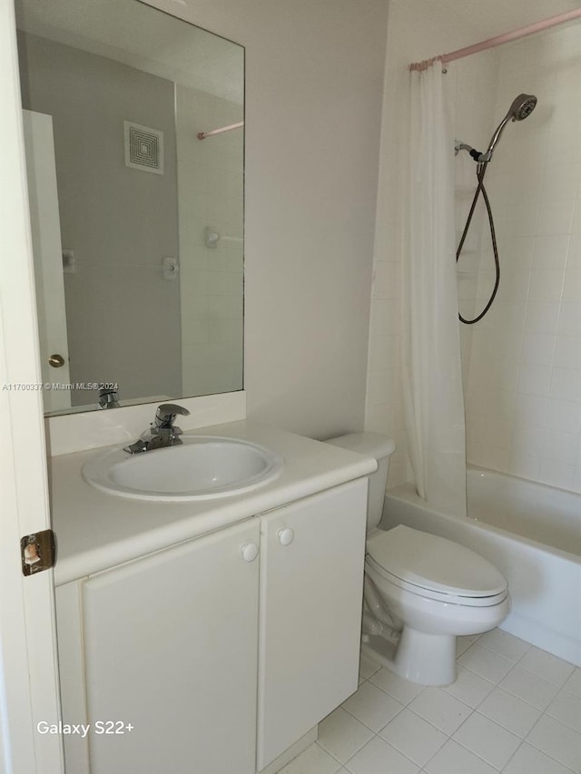 full bathroom featuring toilet, vanity, tile patterned floors, and shower / bathtub combination with curtain