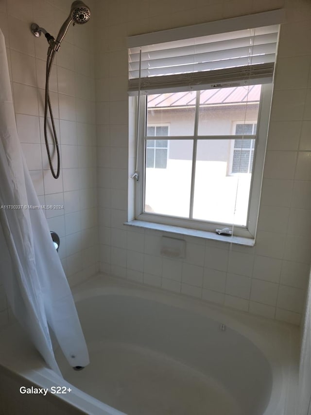 bathroom with shower / bath combo with shower curtain and plenty of natural light