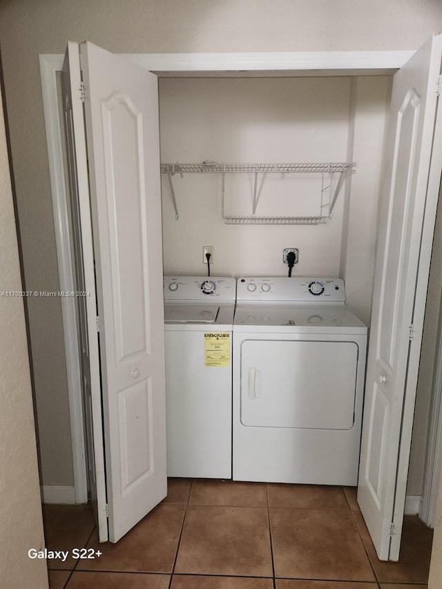 clothes washing area with tile patterned flooring and independent washer and dryer